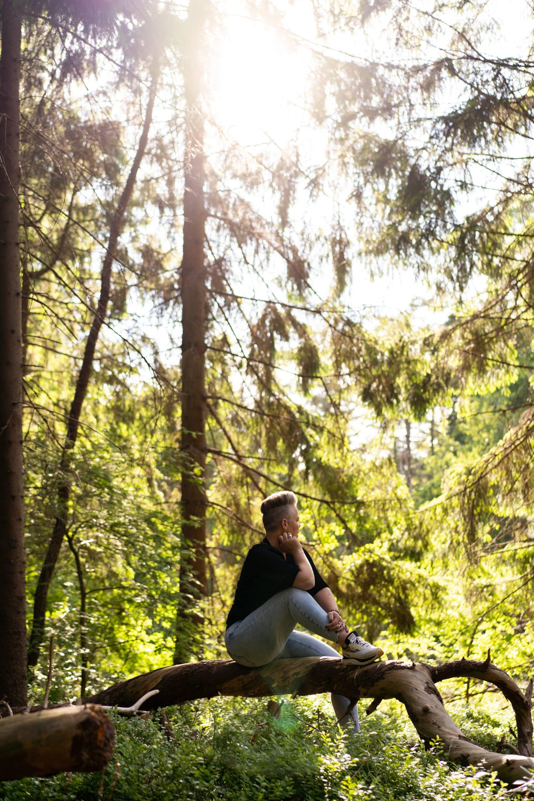 Jolanda Pouwels zit op een tak in het groene bos.